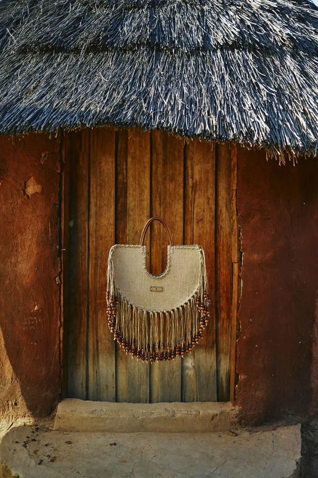 Beaded Fringe Tote displayed against a traditional clay wall